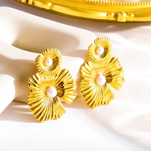 Detailed macro shot of golden flower earrings with embedded pearls and textured petals
