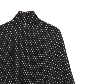 Detail of high neck black shirt with white polka dots and light breathable fabric