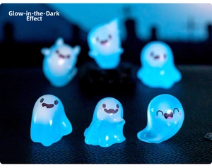 Detailed view of six mini cartoon resin ghosts glowing bright blue in the dark