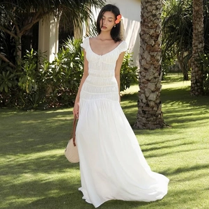 Détail de la robe longue blanche à col en V avec tissu texturé plissé en plein air