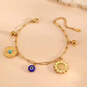 Detailed view of a gold chain bracelet with evil eye, sunflower, and sun pendants