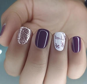 Macro detail of French style press-on nails with purple floral art and silver glitter accents