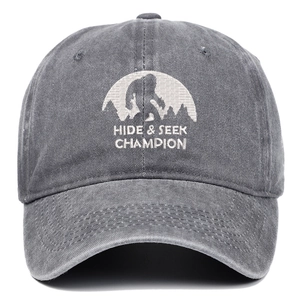 Detail of white embroidery with Bigfoot silhouette on washed grey cotton baseball cap