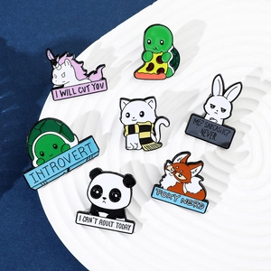 Close-up of cute cartoon animal enamel pins including panda and rabbit on a white plate