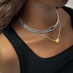 Detail of layered gold and silver Cuban link chain with sparkling diamond bead pendant