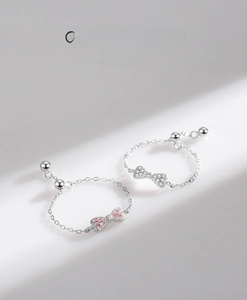 Detailed view of 925 sterling silver bow rings with pink and white zircon micro-inlay