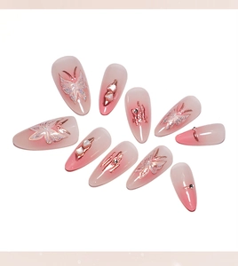 Macro view of pink blush gradient press-on nails featuring glittery butterfly ornaments