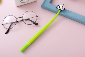 Close-up of cute panda silicone ornament on green gel pen with creative stationery props