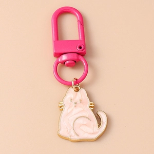 Macro shot of cute pink enamel cat keychain with golden trim and metal clasp details
