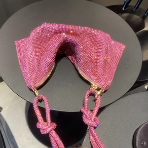Detailed close-up of pink rhinestone hobo bag featuring a unique knotted handle design