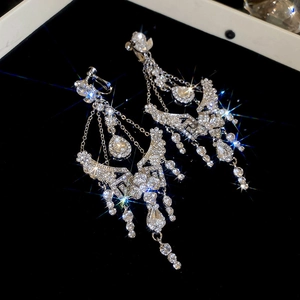 Macro shot of silver tassel earrings featuring sparkling waterdrop pendants and rhinestones