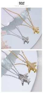 Macro shot of 18K gold and silver airplane pendants with pave-set shimmering crystals