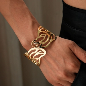 Detailed view of a golden butterfly cuff bracelet with intricate hollow pattern on wrist