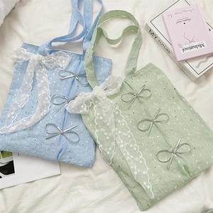 Close-up of sequin canvas tote bags featuring large lace bows and silver metal charms