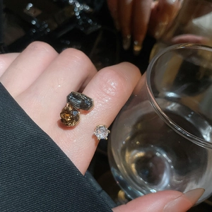 Detail of adjustable gold ring with smokey grey rectangle and amber zircon stones