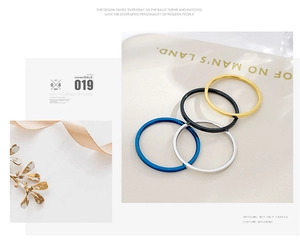 Set of four minimalist stainless steel rings in blue, silver, black, and gold finishes