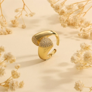 Detailed view of gold multi-layer ring with sparkling zircon and dried flower background