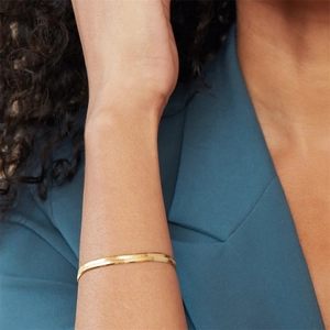 Nahaufnahme eines goldenen flachen Schlangenkette-Armbands am Handgelenk mit Politur