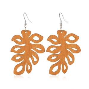 Detailed view of hollow monstera leaf wood earrings in coffee brown finish