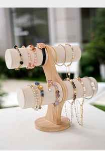 Detail of two-tier bamboo jewelry display stand with beige velvet rolls in nature