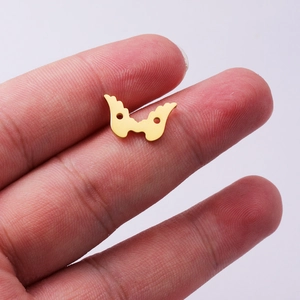 Polished gold stainless steel angel wings connector charm held in hand for DIY jewelry