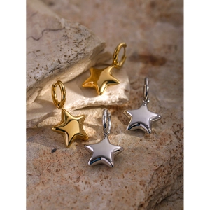 Gros plan de boucles d'oreilles étoiles 3D en finitions or et argent polies