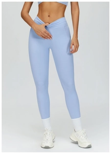 Detail of high waisted blue yoga pants featuring a stylish V-cross front waistband design