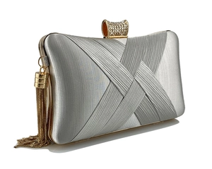 Close-up of silver pleated satin evening clutch with rhinestone clasp and gold tassels