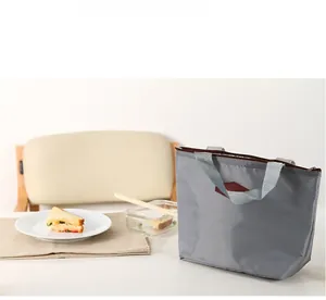 Gray insulated lunch bag on a dining table showing large capacity for food storage