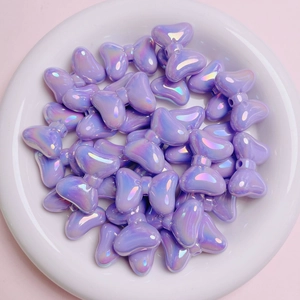Macro shot of purple iridescent bow-shaped acrylic beads for DIY jewelry making