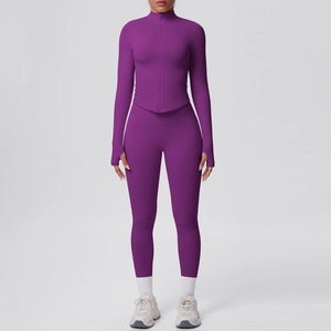 Dettaglio del set yoga viola con polsini con foro per il pollice e leggings a compressione elasticizzati