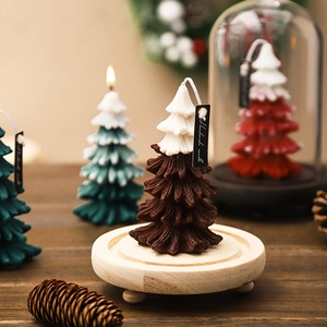 Handmade Christmas tree scented candle in brown and green tones on a wooden base