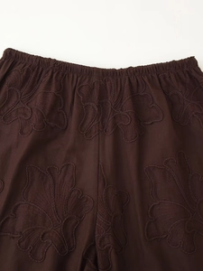 Détail macro d'une broderie florale de qualité et taille élastique sur ensemble marron