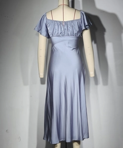 Détail d'une robe en satin avec décolleté carré froncé et manches courtes à volants