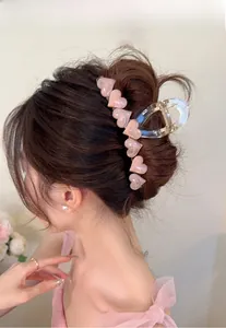 Detail of pink marble heart hair claw clip styled in an elegant updo for women