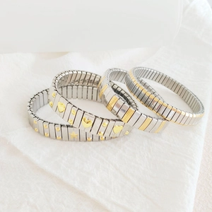 Close-up of gold and silver stainless steel modular heart and star stretch bracelet