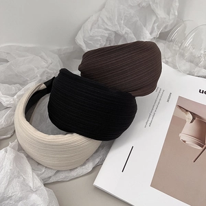 Detail showing beige black and brown textured wide headbands in a stylish stack