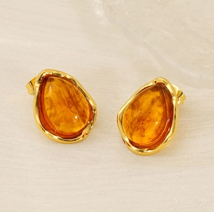 Detailed close-up of water drop earrings with amber stones and organic gold edges