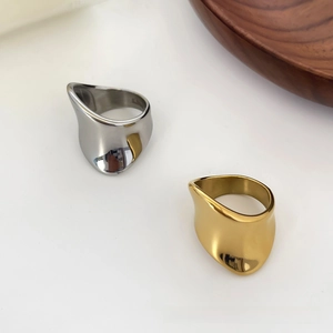 Detailed macro view of irregular wavy stainless steel rings in gold and silver finish