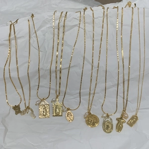 Detail of gold religious necklaces with Virgin Mary pendants and freshwater pearl accents