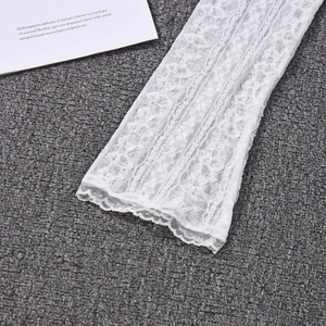 Detail of white sheer lace bell sleeve showing intricate floral embroidery texture
