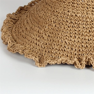 Close-up of handmade straw hat featuring natural woven fibers and wavy brim details