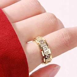 Close-up of gold geometric wheat-style ring with sparkling zircon stones on finger