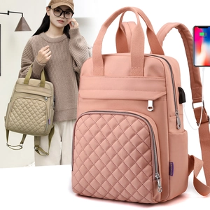 Pink nylon backpack detail showing a side USB charging port and quilted diamond pattern