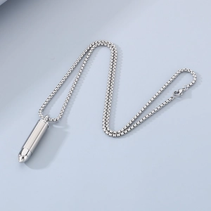 Macro detail of silver bullet pendant with box chain made of polished stainless steel