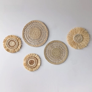 Macro detail of 5-piece bohemian wall decor set with raffia weave and tassel textures