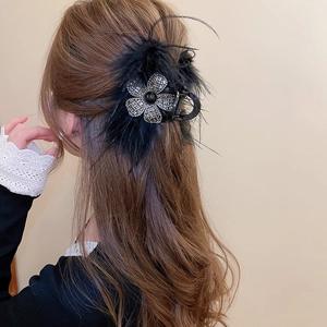 Vue détaillée de la pince à cheveux plume noire avec fleur de diamant étincelante