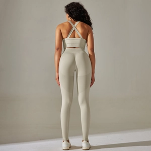 Detail of cross-back sports bra and seamless high-waist yoga leggings set in sage green
