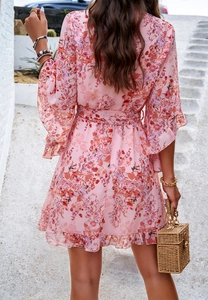 Detail of pink floral chiffon mini dress with ruffled hem and matching belt back view