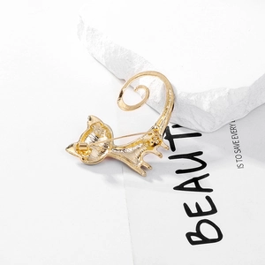 Golden cat brooch with oil-painted tail showing the back view and safety pin structure
